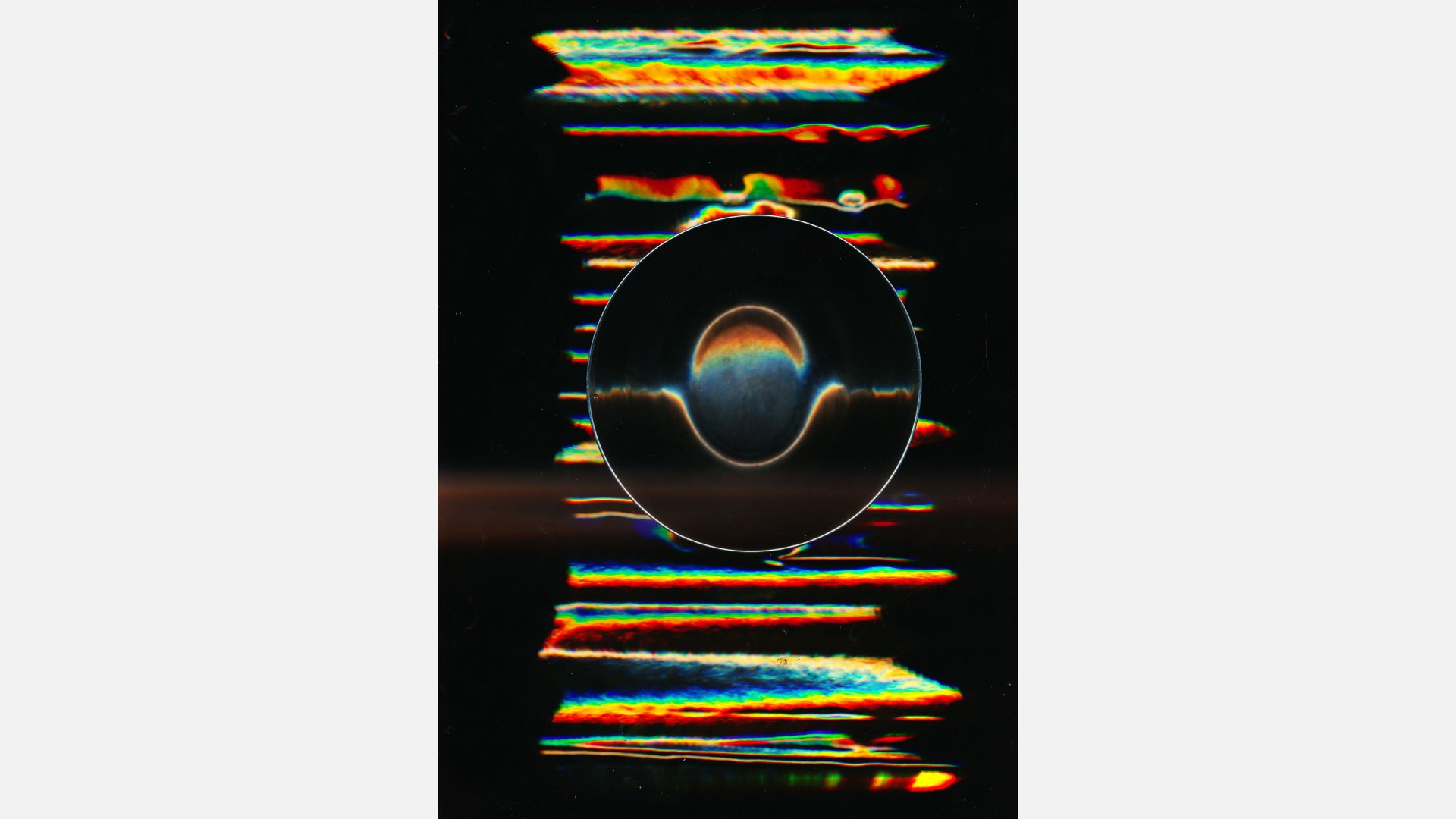 A digital image created by a flatbed scanner of horizontal red, yellow, and green stripes against a black blackground. In the centre is black circle containing an egg-like shape resting in a groove.