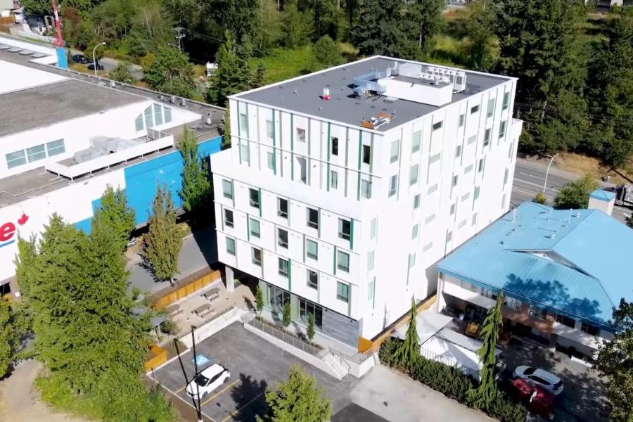 An aerial of a white square low rise building next to a Superstore
