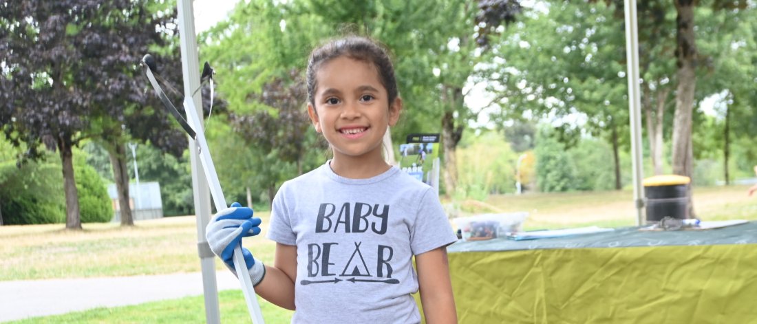 young girl holding a litter pick 