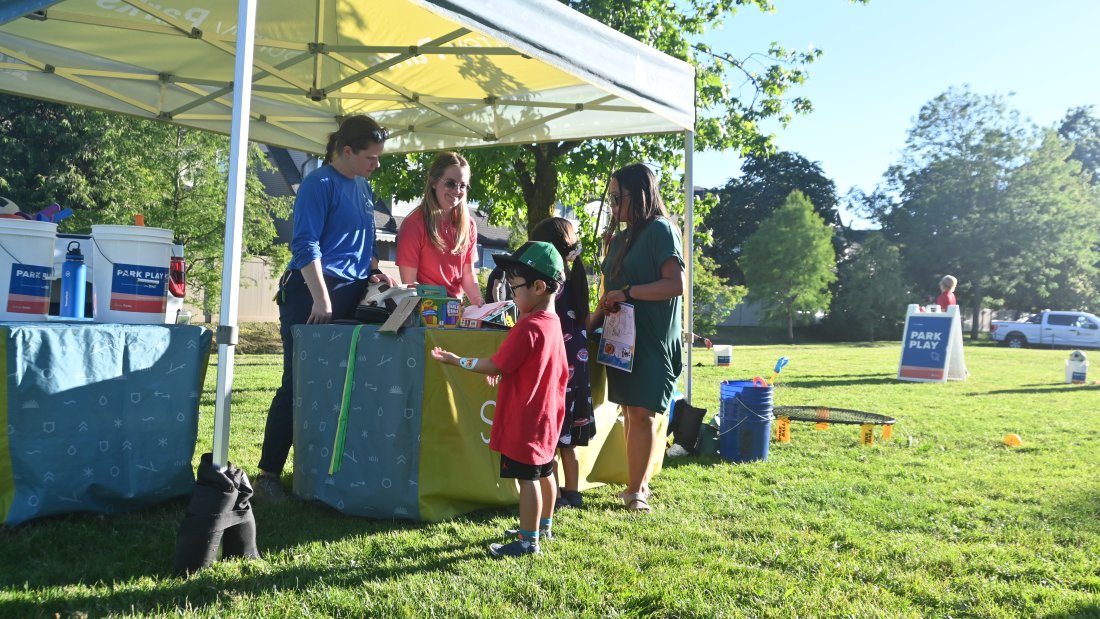 program staff hand out sporting equipment to patrons