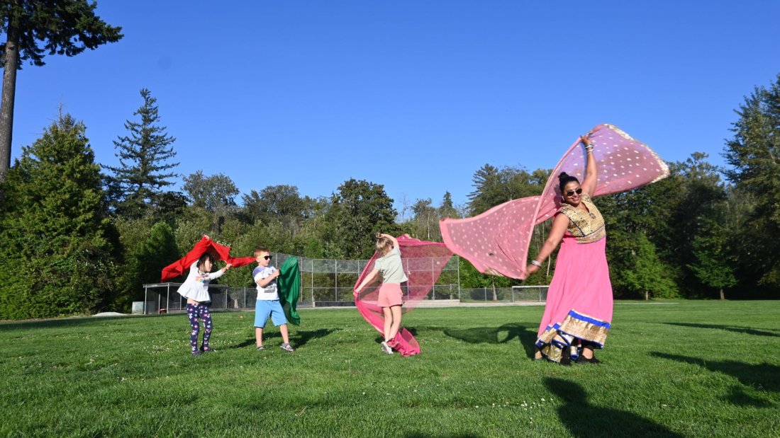 three children follow along a bollywood dance performer