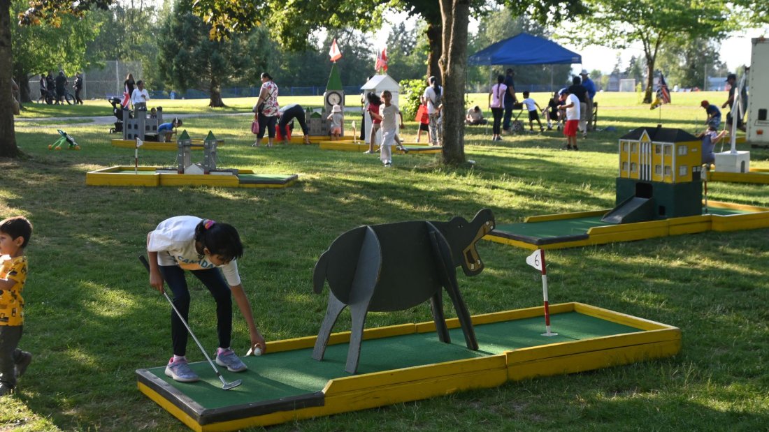 a child plays mini golf at a community picnic