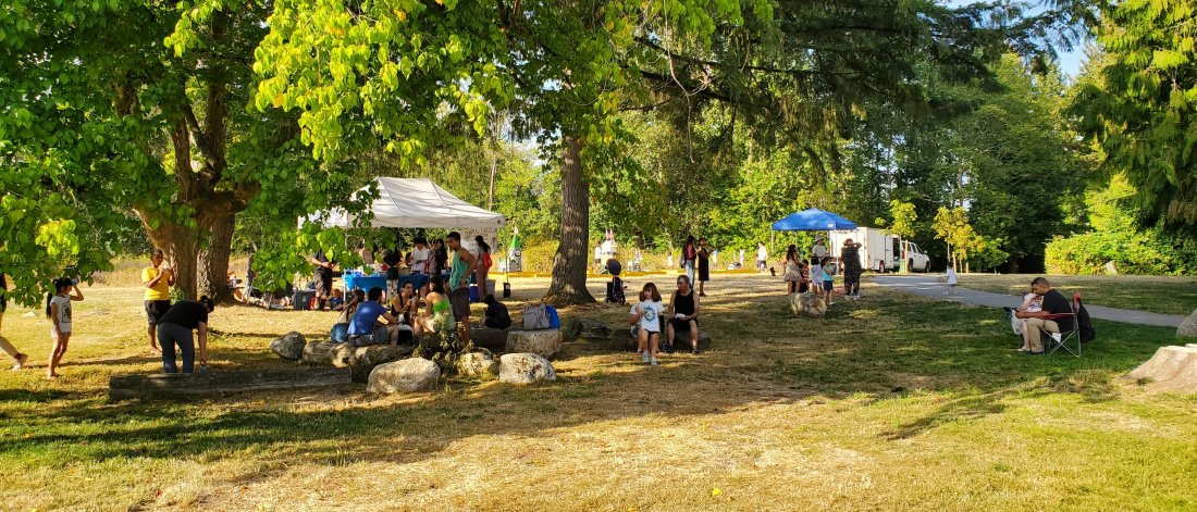 a collection of tent and people at a community picnic