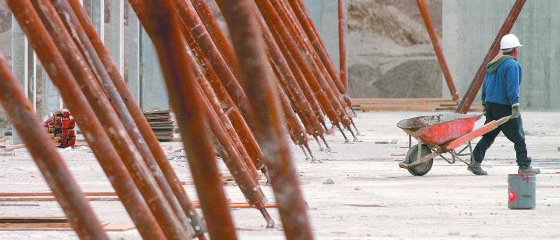 Man pulling wheelbarrow at construction site