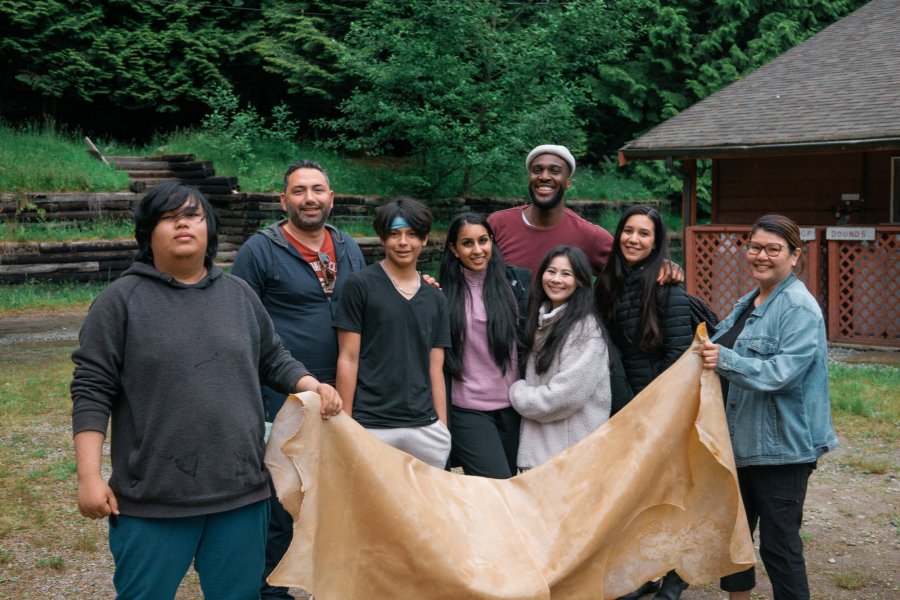 a group of people hold an animal skin