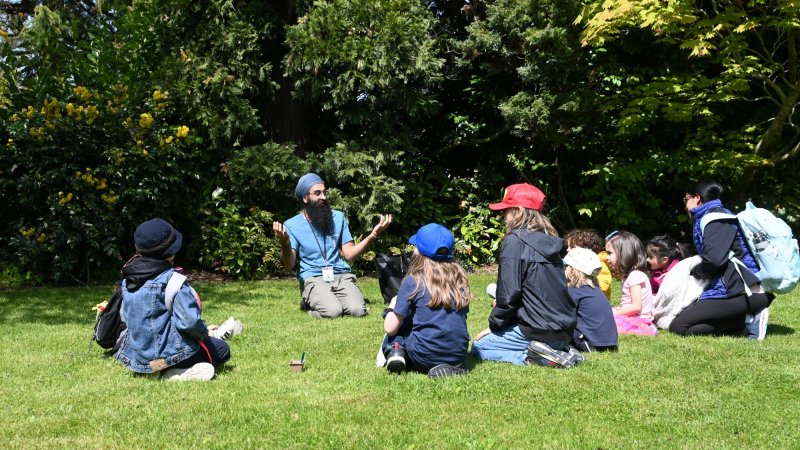 a program leader tells a story to a circle of children