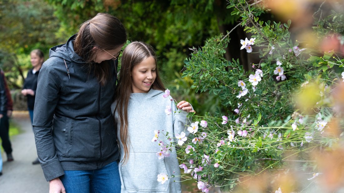 mother and daughter admire flowers