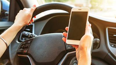 Distracted Driving with phone in hand 