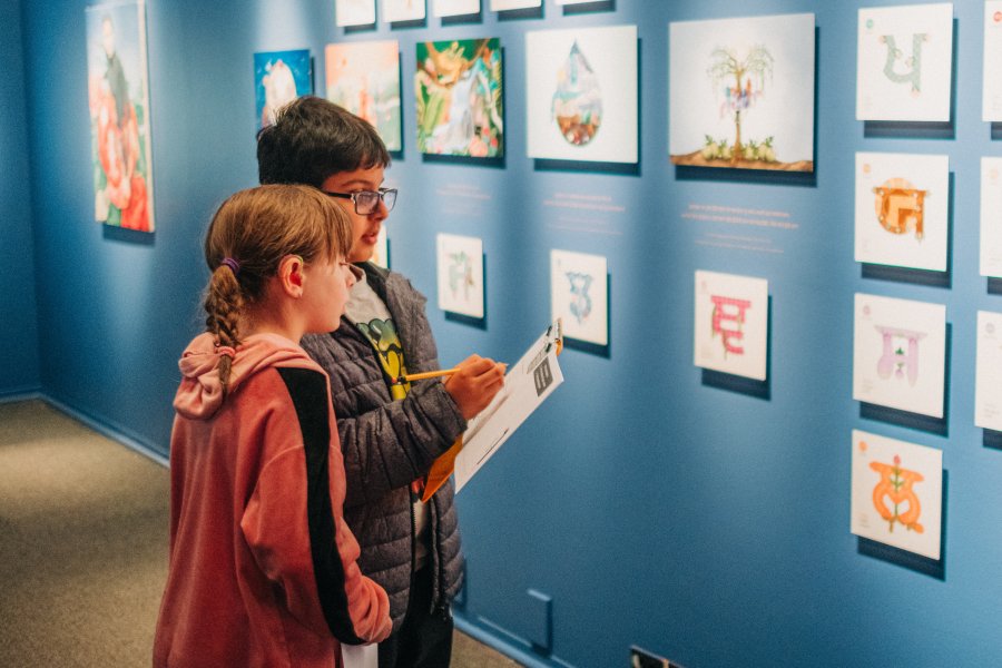 Two children are engaging in the Art Explorer Guide for Keerat Kaur: Panjabi Garden exhibit.