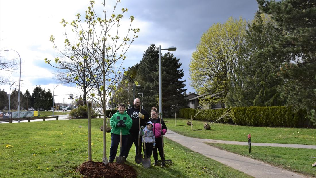 Family next to a tree.