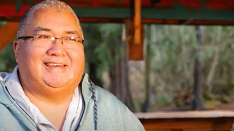 An indigenous man smiling giving an interview