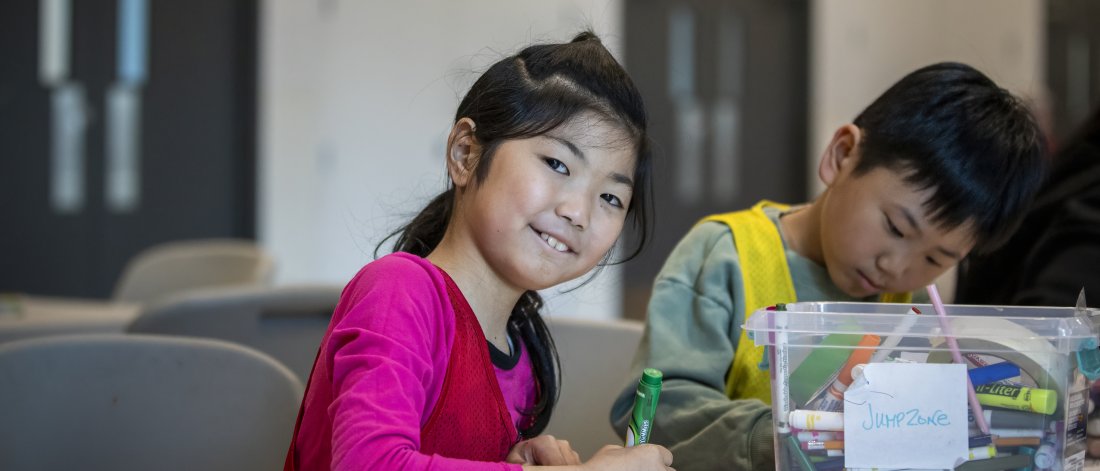 A girl smiling while making crafts.