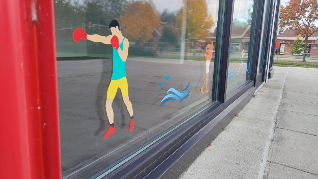 Cartoon decals on a window of a red building at a park