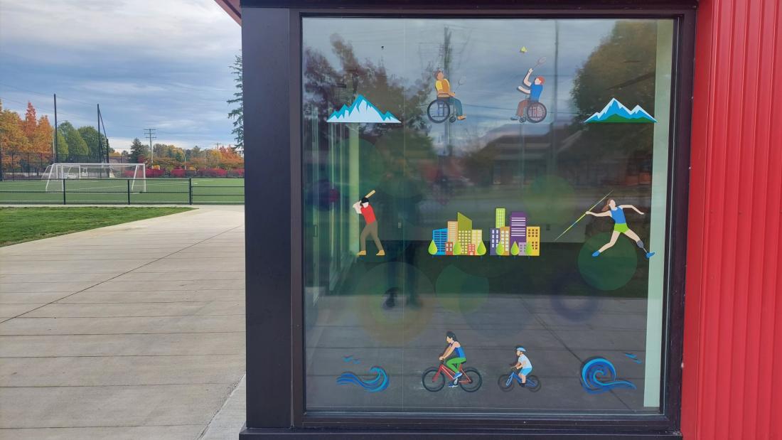 Cartoon decals on a window of a red building at a park