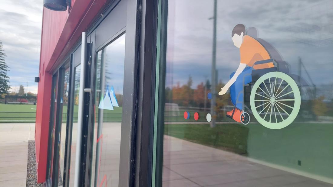 Cartoon decals on a window of a red building at a park