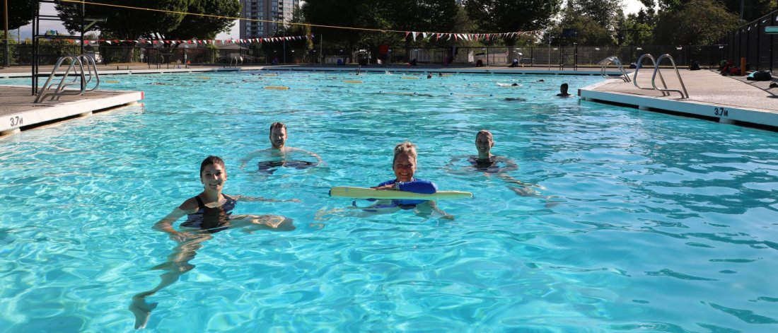An outdoor pool with people swimming.