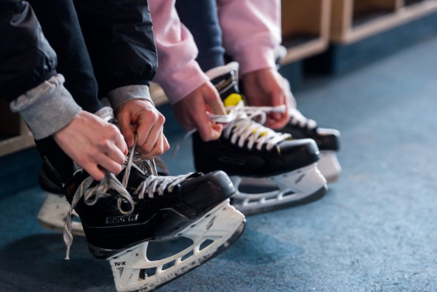 People tying their hockey skates.