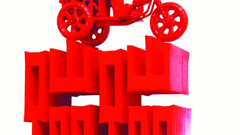 Large red script and a truck on top of it with the same letters that spell “beng beng” the colloquial name for a three-wheeled taxi found in Beijing.