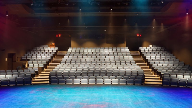 main stage theatre at surrey arts centre looking from the stage with blue and red lighting  
