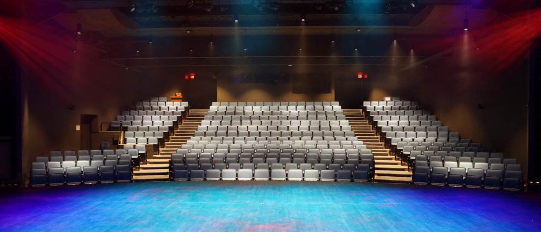 main stage theatre at surrey arts centre looking from the stage with blue and red lighting  