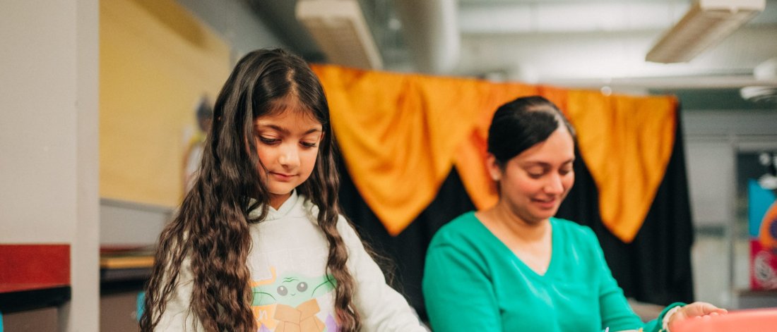 Two females making wearable art.