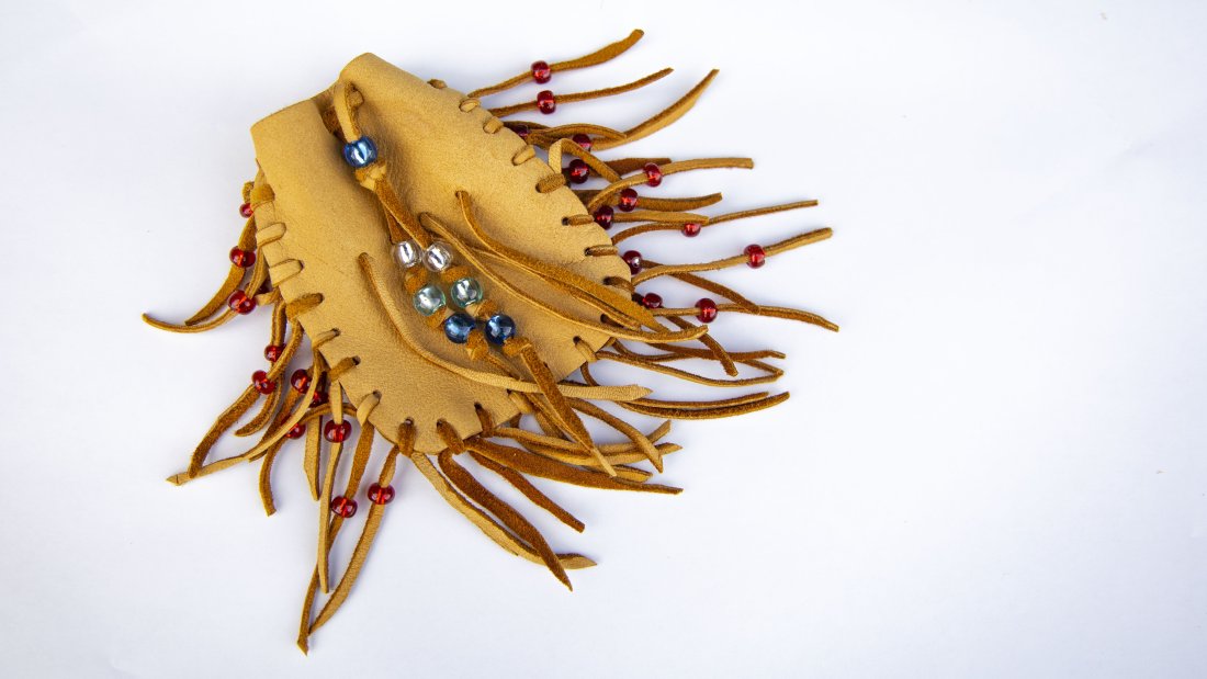 a handcrafted traditional medicine pouch on a white surface