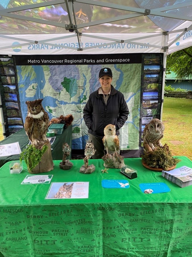 Educational booth featuring owl specimens and regional park maps.