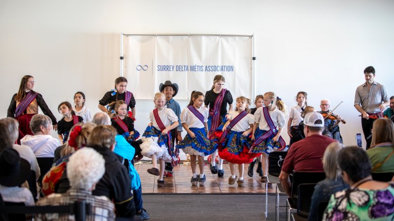 Attendees watching performances at the Metis: Children of the Fur Trade event