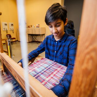 Person using a loom at the Textile Centre