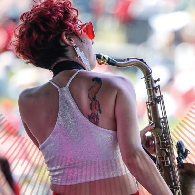 Woman facing a crowd playing a saxaphone