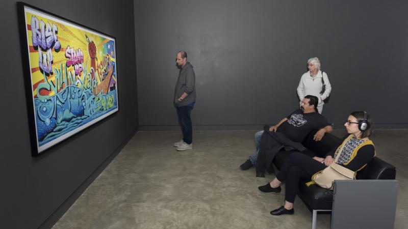 Visitors looking at a colourful painting 