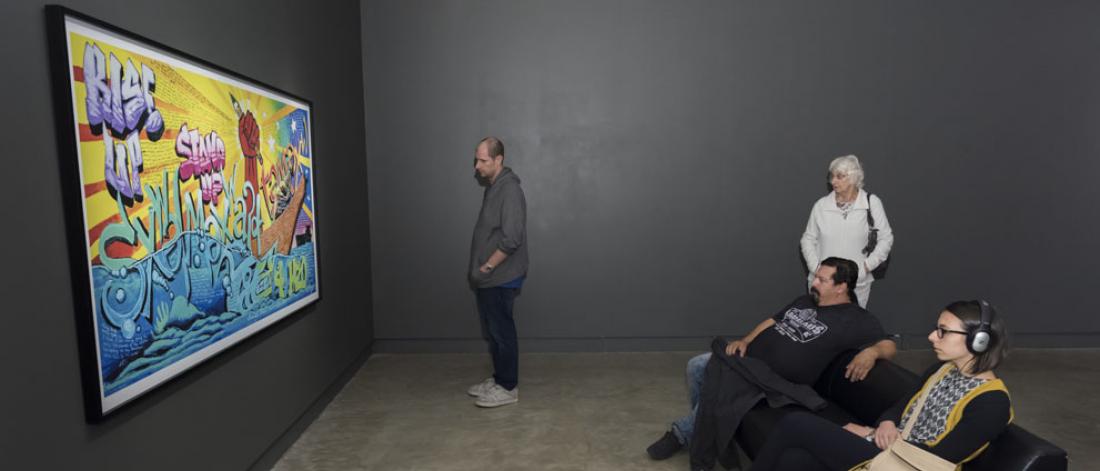 Visitors looking at a colourful painting 