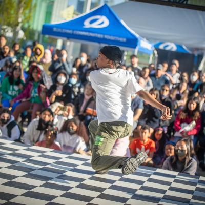 a youth dancing with a crowd cheering them on