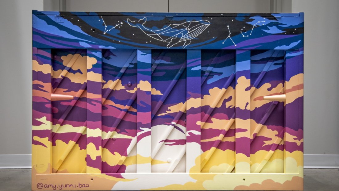  A painted piano with an underwater ocean theme, featuring coral and fish, on display in an indoor setting.