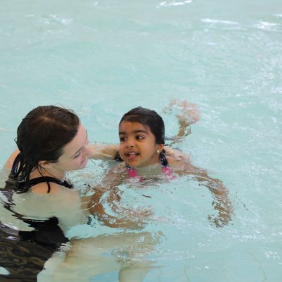 A parent swimming with their child.