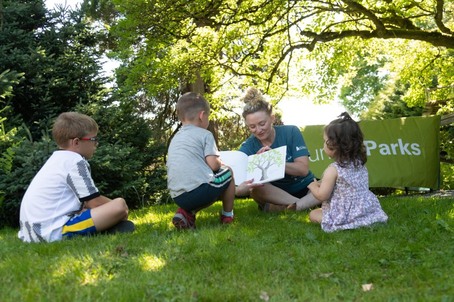 Outdoor storytime session with children in a park setting.
