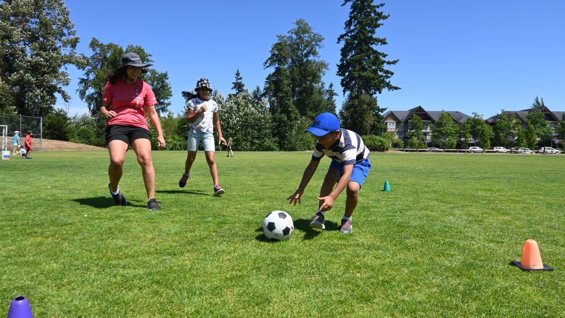 boy reached to grab a soccer ball from the ground