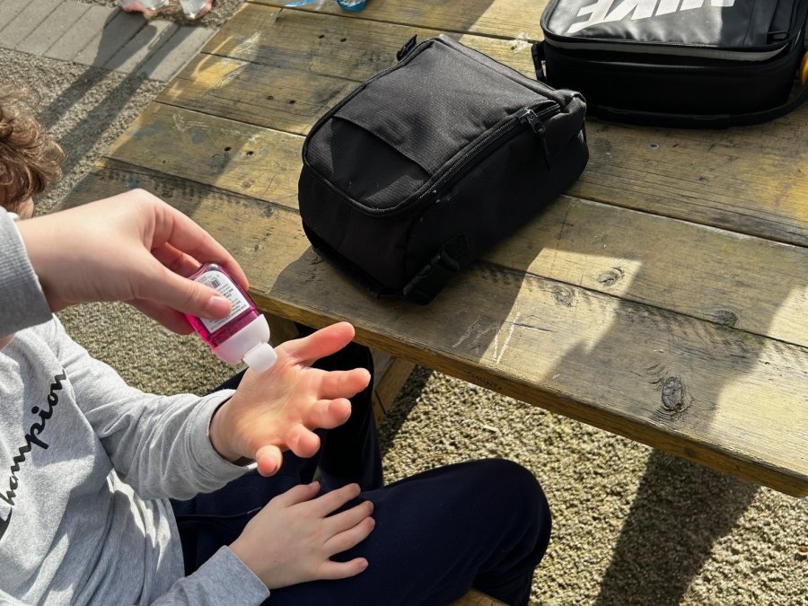 A person putting hand sanitizer in someone else's hands.