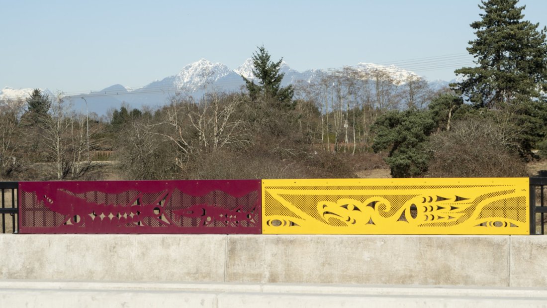 A side path with colorful barrier panels under a blue sky.