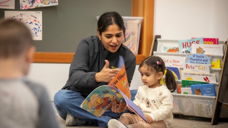 Preschool teacher reading with child