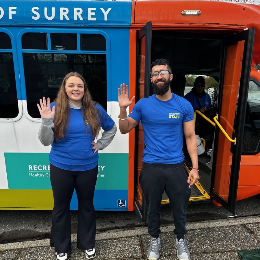 Two people in blue t-shirts waving.