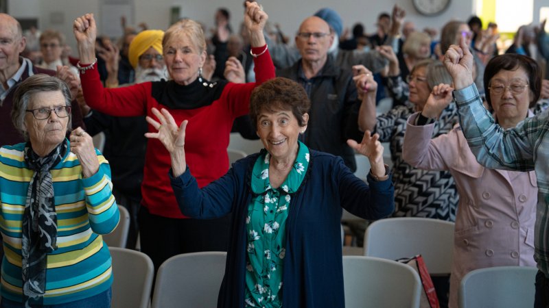 Seniors standing up, smiling and enjoying a group activity.