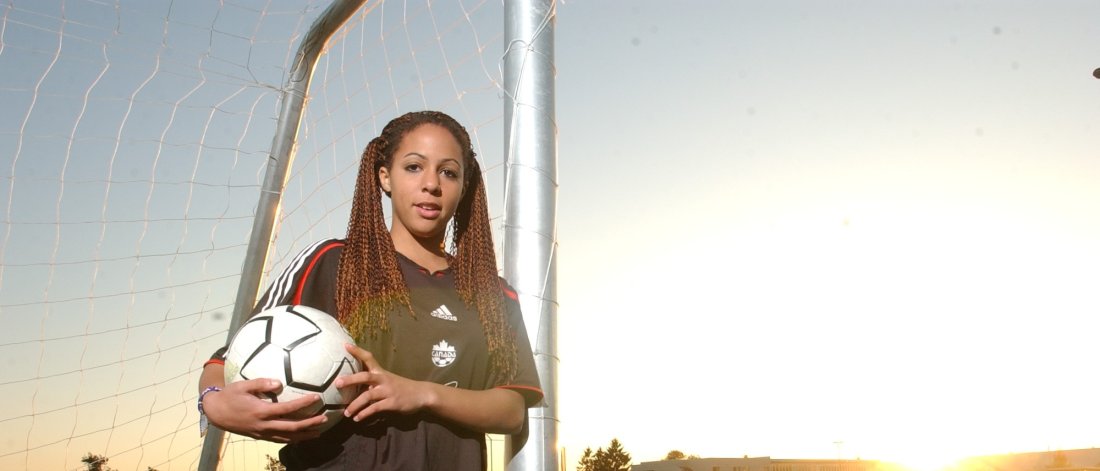 female soccer player poses with ball