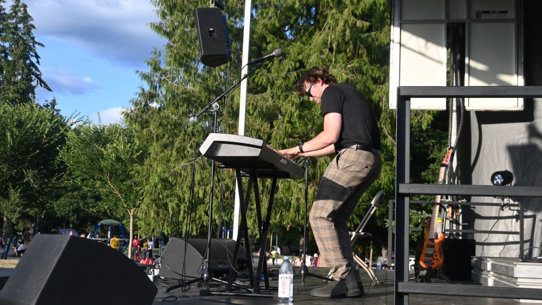 a musician plays the keyboard on an outdoor stage
