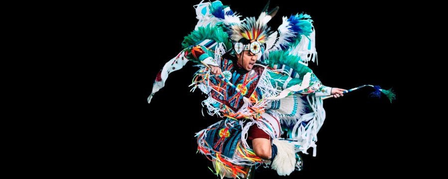 Dancer Notorious Cree in full colourful regalia on a black background