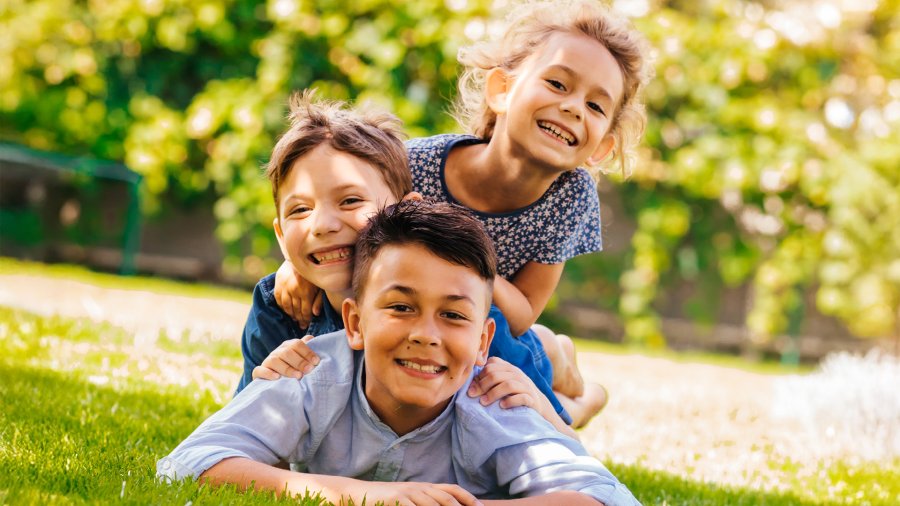 Kids laying in the park smiling.