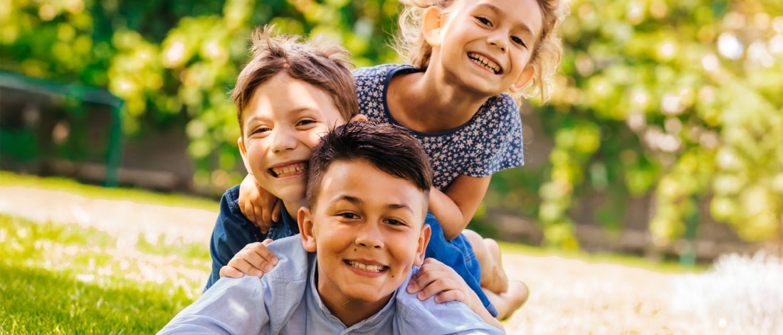 Kids laying in the park smiling.