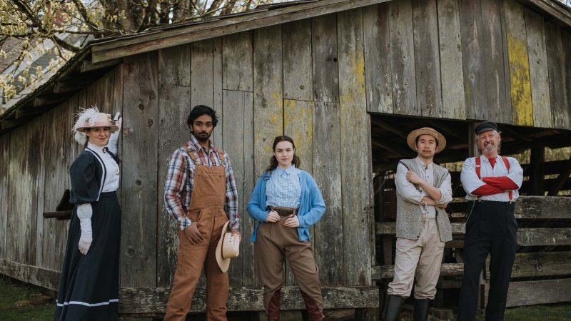 The Re-enactors troupe posing in front of a heritage barn