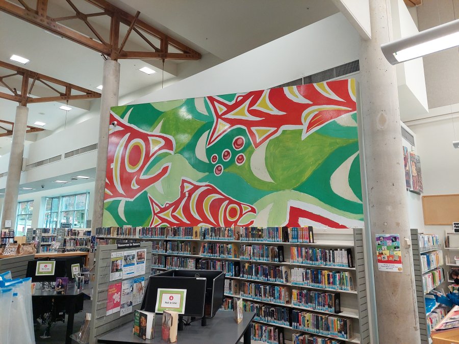 Green and red Indigenous fish mural on a library wall