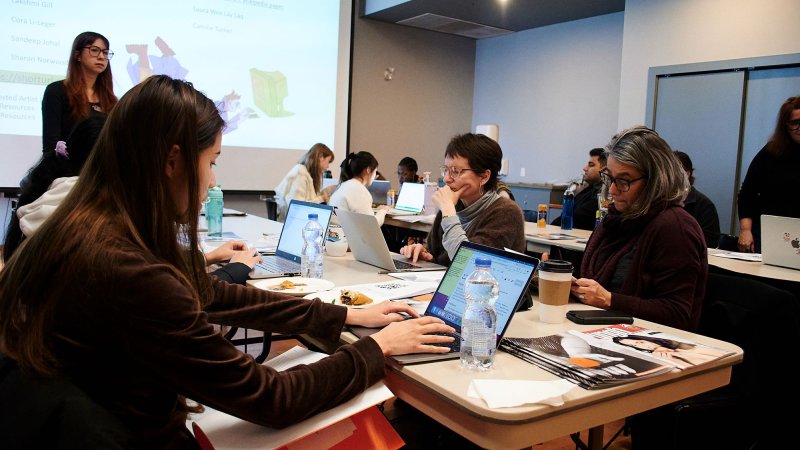 Participants at a Wikipedia edit-a-thon working on laptops in a collaborative setting.
